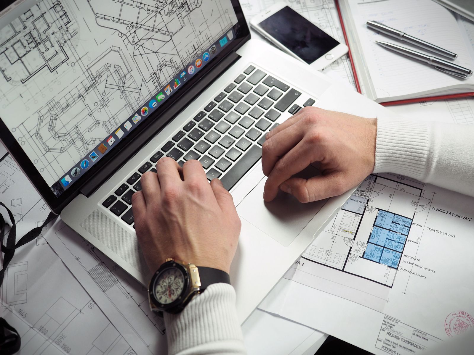 Dossier et plans ouverts sur la table de travail