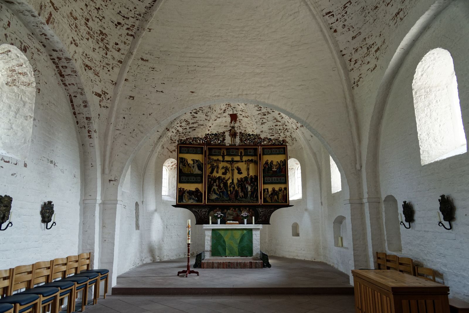 La nef blanchie à la chaux de l'église et son retable peint, avant le concert