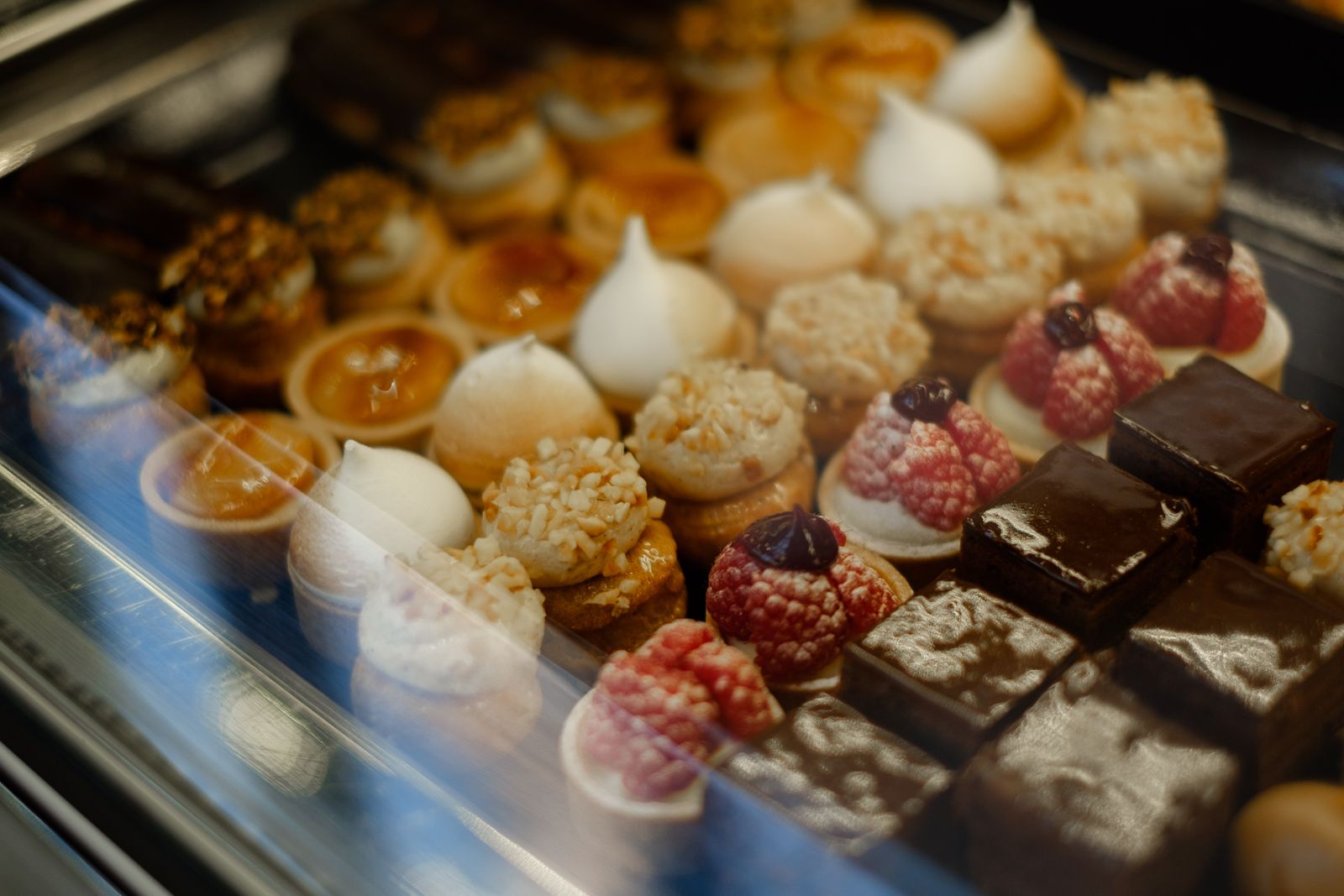 Des petits gâteaux et tartelettes alignés dans une vitrine réfrigérée