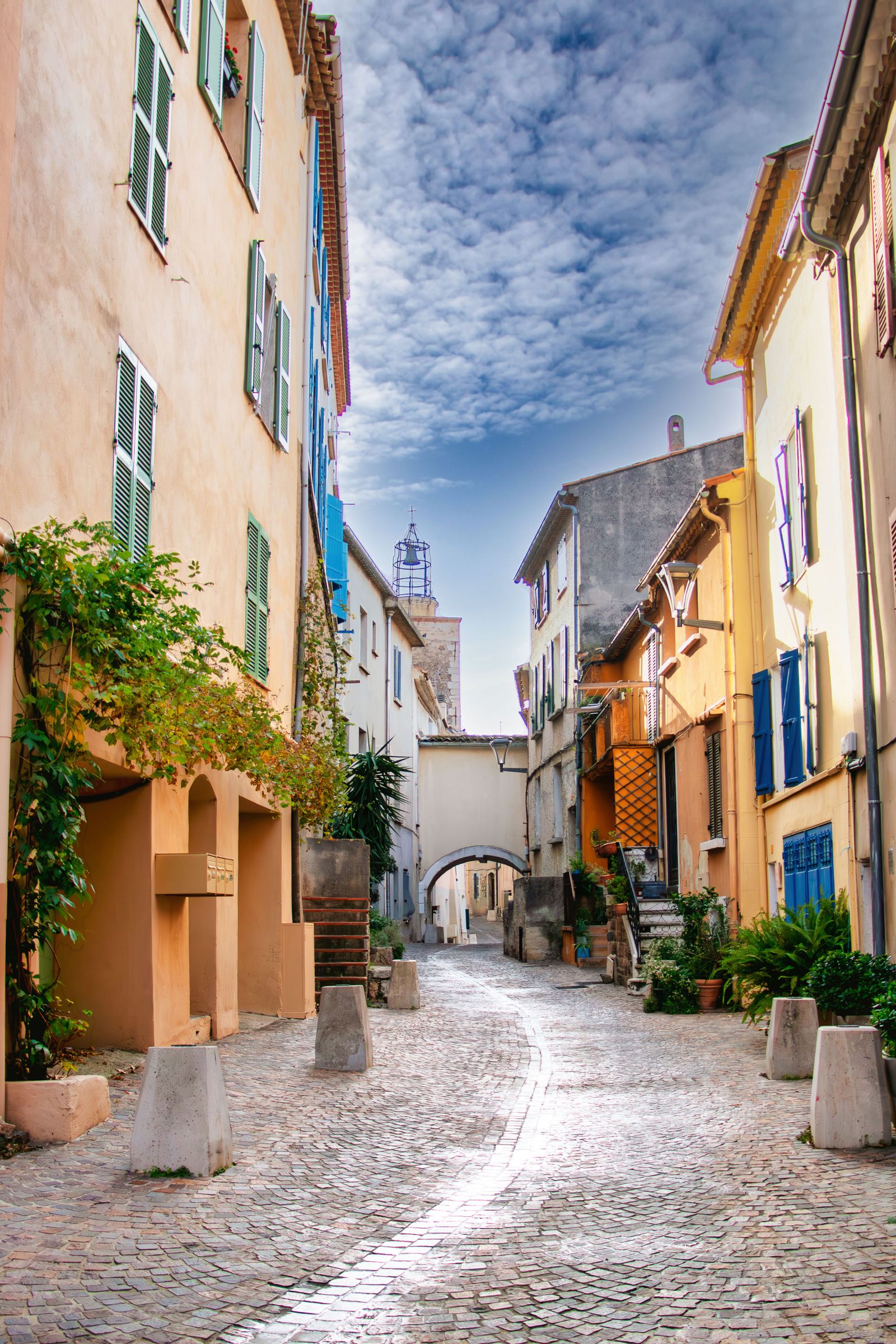 Une ruelle pavée de la bastide, ses façades ocre et son passage voûté