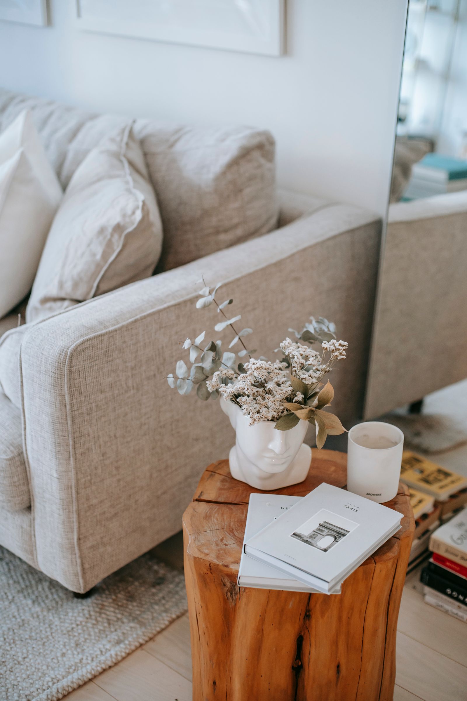 Coin de canapé avec fleurs séchées et livre posé