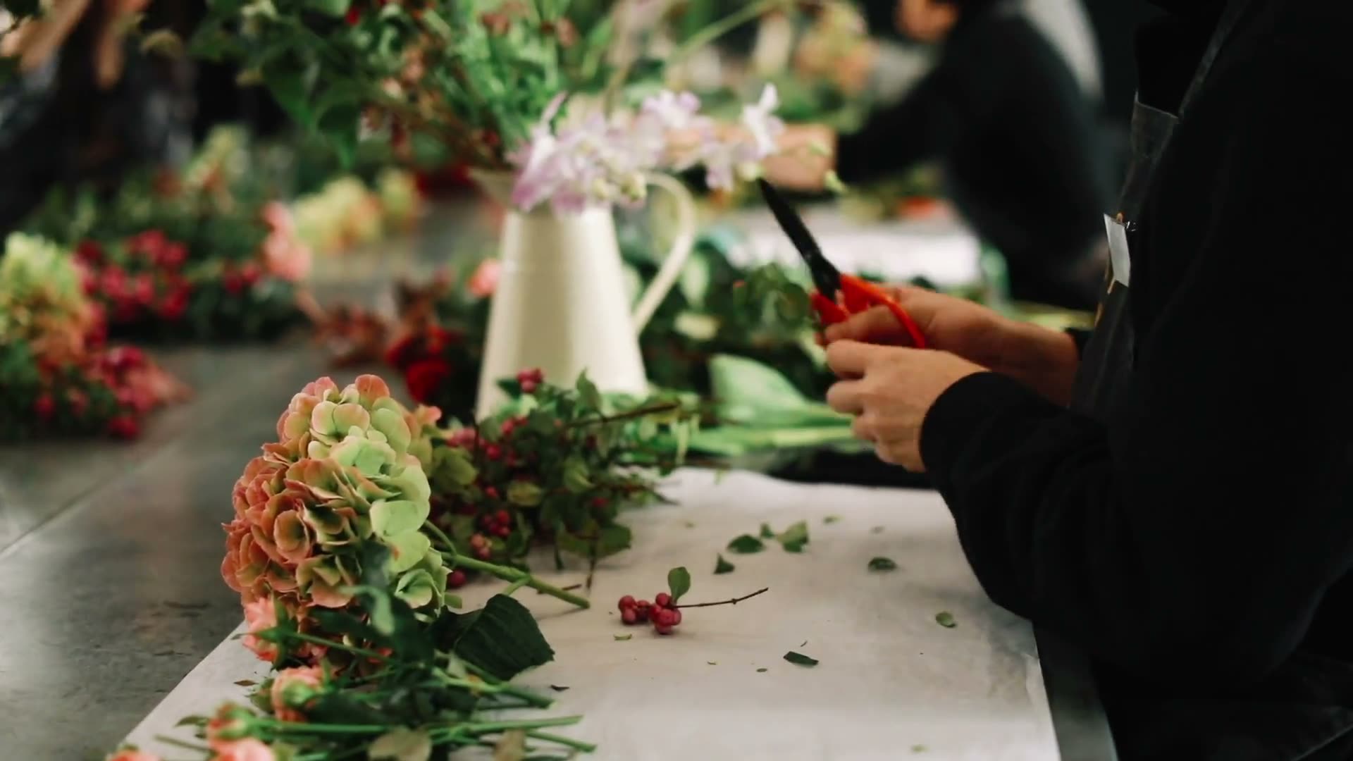 Fleuriste composant un bouquet sur son plan de travail
