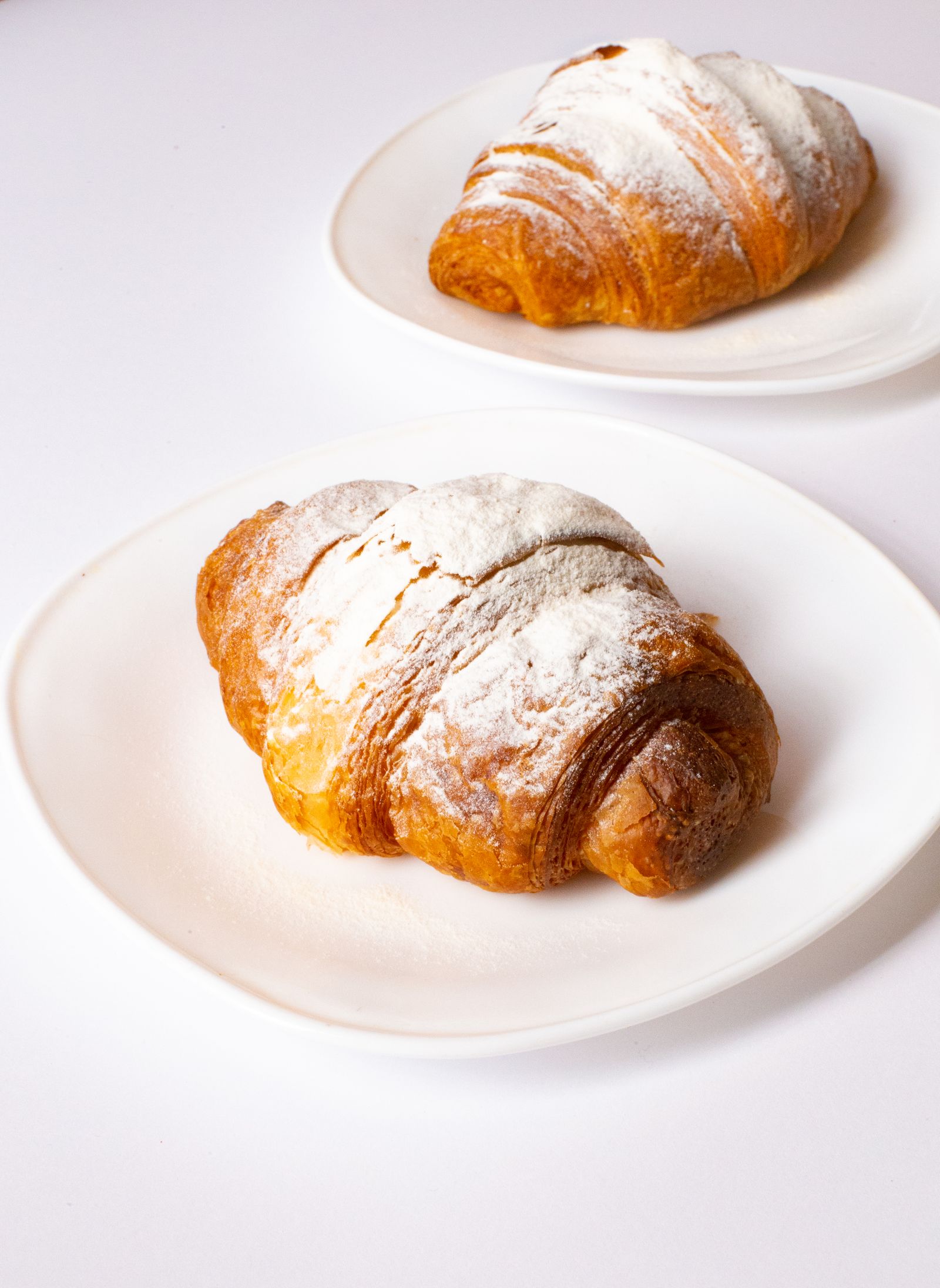 Croissant poudré sur assiette blanche