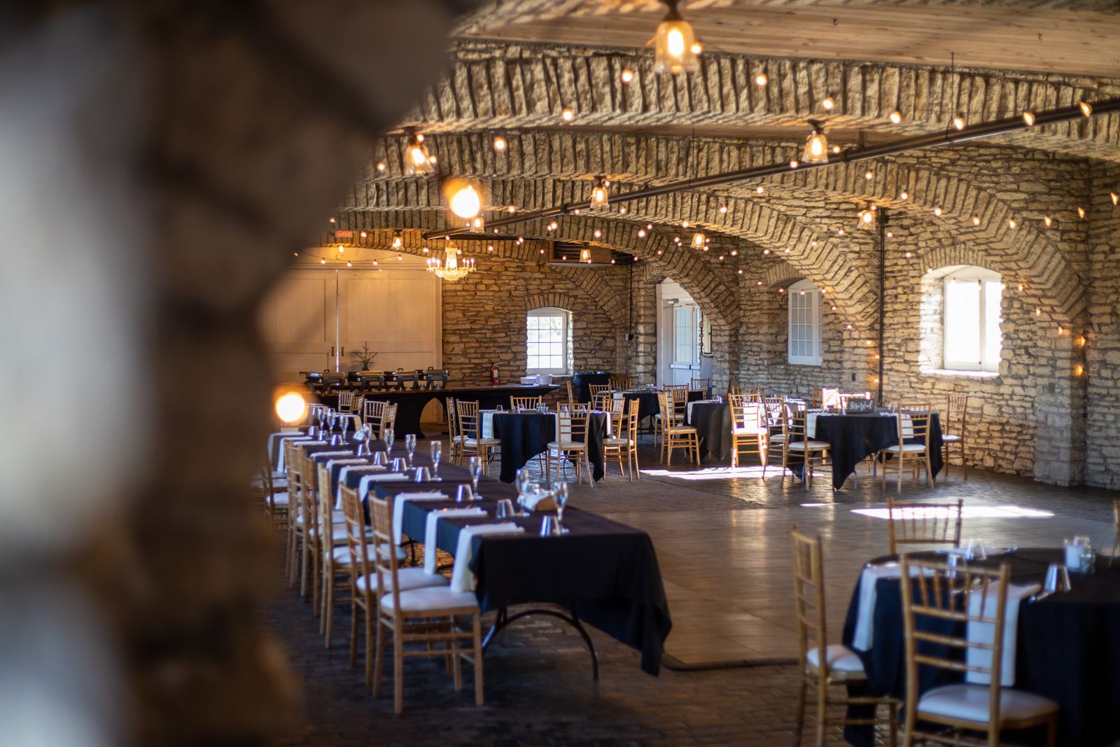 La grande salle en pierre dressée pour un repas, guirlandes allumées