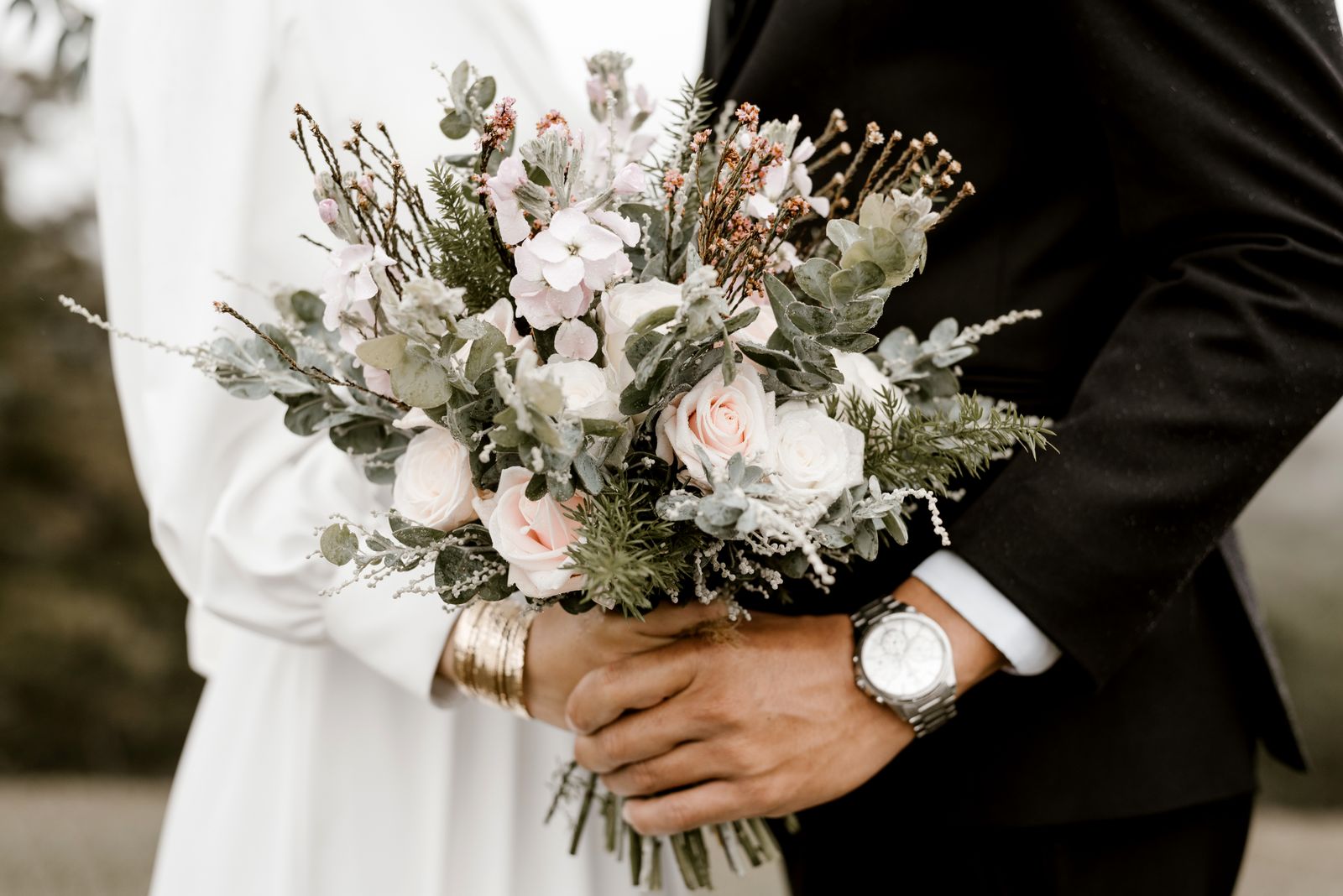 Le bouquet tenu par le marié, montre au poignet