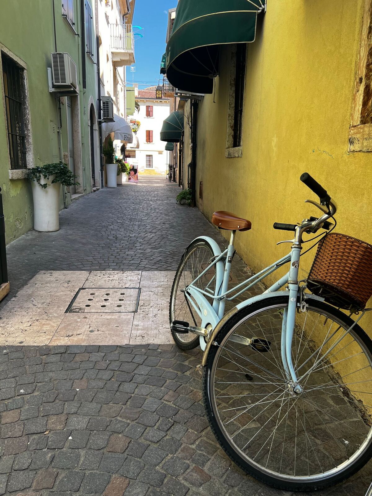 Un vélo posé contre une façade jaune du bourg