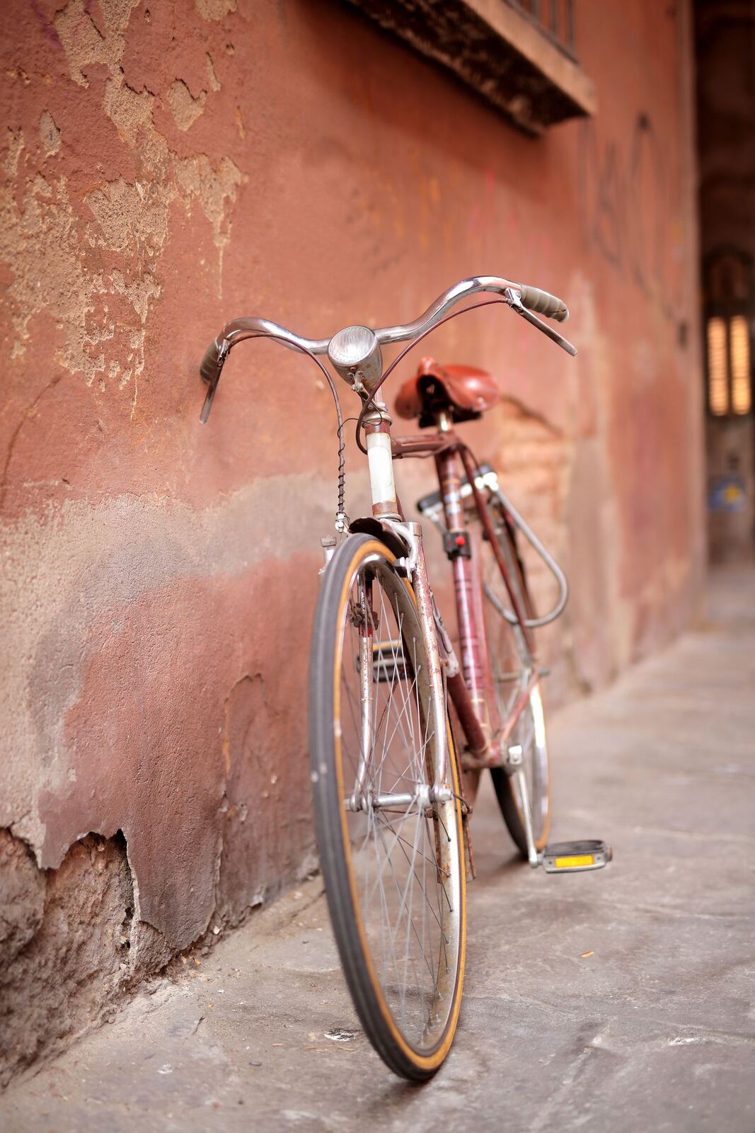 Un vélo contre le mur ocre du presbytère