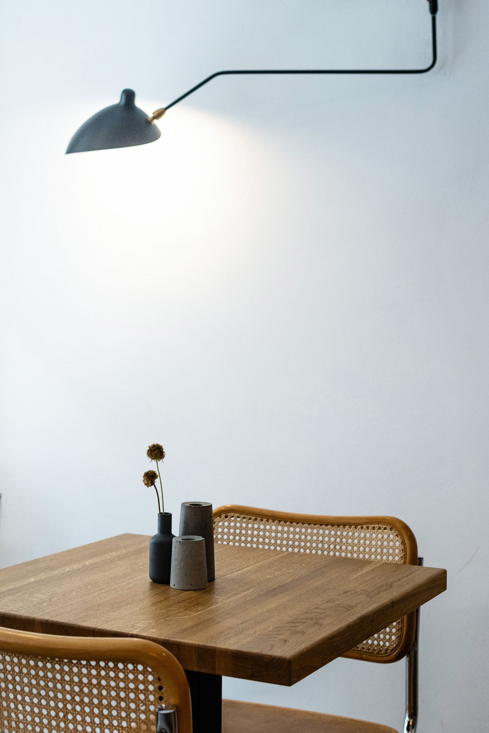 Table et chaise cannée sous une applique
